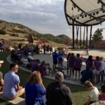 Participants gather in front of the grand outdoor stage in Colorado.