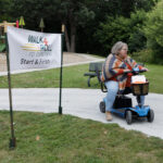 A Dakotas participant in a power chair rolls past the sign during the event.