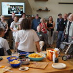 A group od Sips & Smores participants stands and sits around gathering stories.