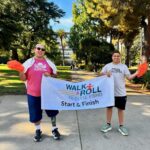 Two Sacramento Walk & Roll participants holding the banner.
